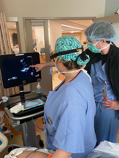 Fellows looking at something on a monitor in a clinical setting